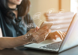 Frau mit Smartphone und Laptop